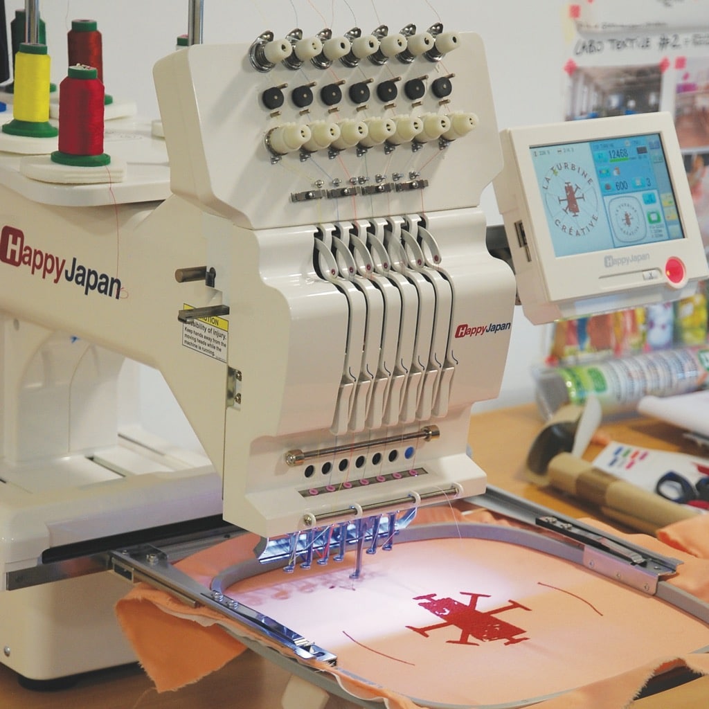 Machine à broder en train de réaliser un motif sur un tissu