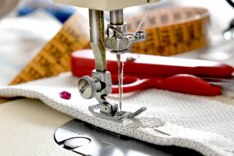 Couturière effectuant une retouche sur un vêtement dans un atelier