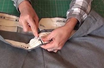 Jean posé sur une table avec des épingles de couture à la taille